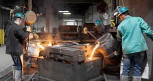 Astech employees pour molten steel into a sand mold produced with 3D printed patterns. 